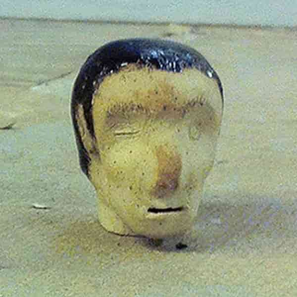 an image of our mascot, August Cake, who is a ceramic human head